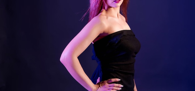 Beautiful woman in a black dress with studio lights