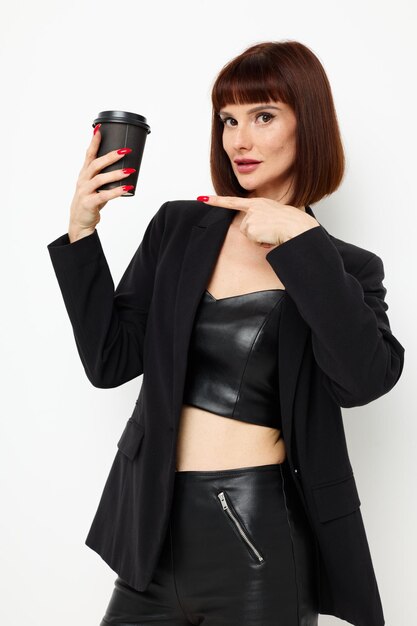 Beautiful woman black jacket drink glass posing light background