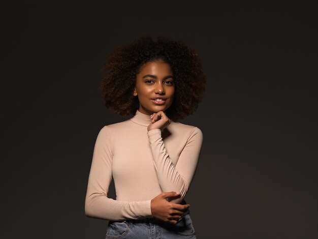Beautiful woman black skin pretty african american beautiful model in sweater on black background.