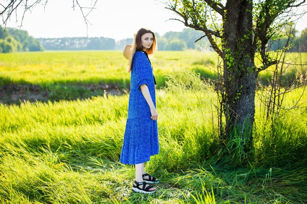 Красивая женщина в голубом платье на поле