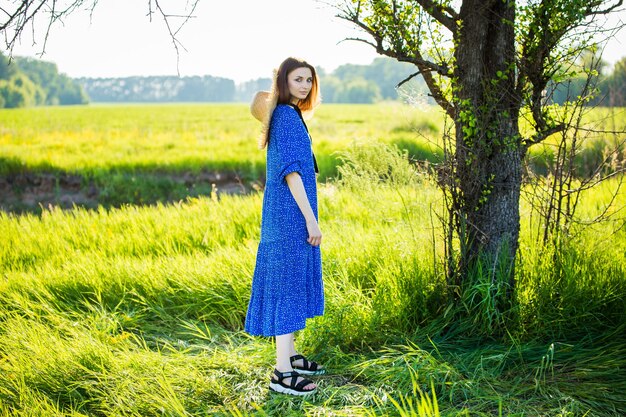 Beautiful woman in a blue dress on the field