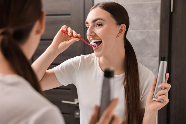 Beautiful woman brushing her teeth in bathroom