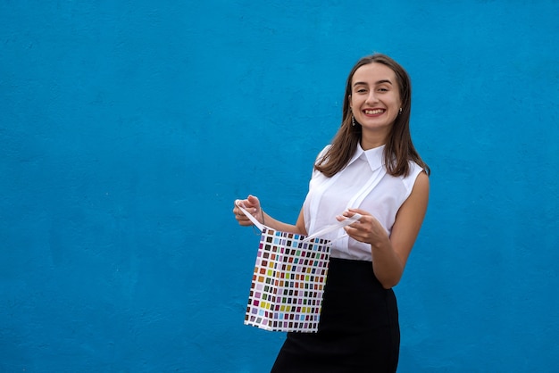 Beautiful woman in business cloth holding shopping bags isolated