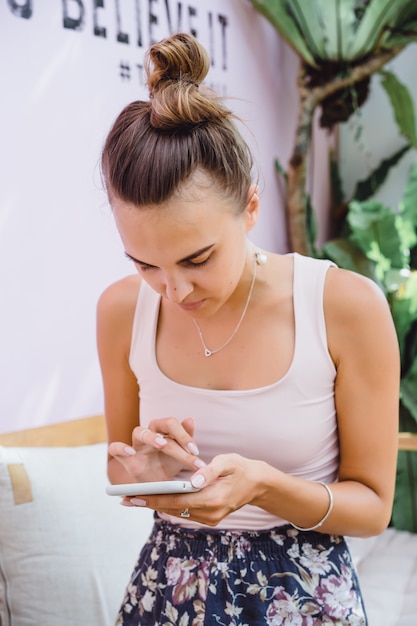 A beautiful woman in a cafe uses a smartphone