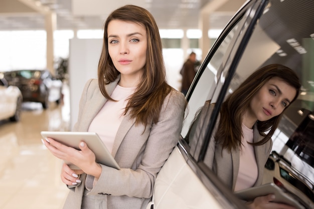 Photo beautiful woman in car showroom