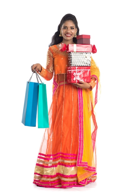 Beautiful woman carrying many shopping bags and gift Box on white