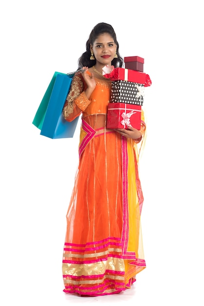 Photo beautiful woman carrying many shopping bags and gift box on white.