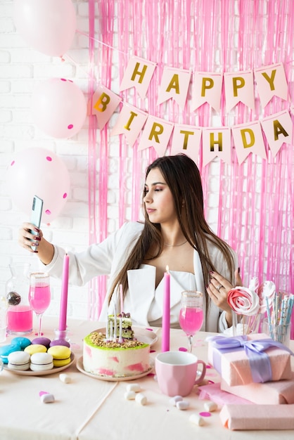 Beautiful woman celebrating birthday party taking selfie