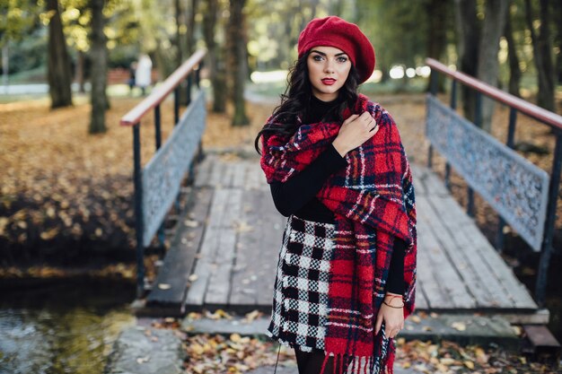 Beautiful woman in checkered scarf near bridge