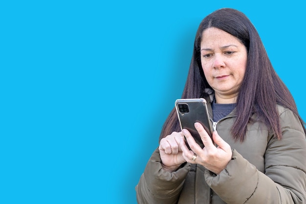 Beautiful woman checks her cell phone very seriously because she doesn't like the news on her phone