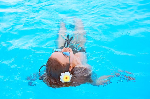 Beautiful woman chilling out by the swimming pool summer recreation travel concept