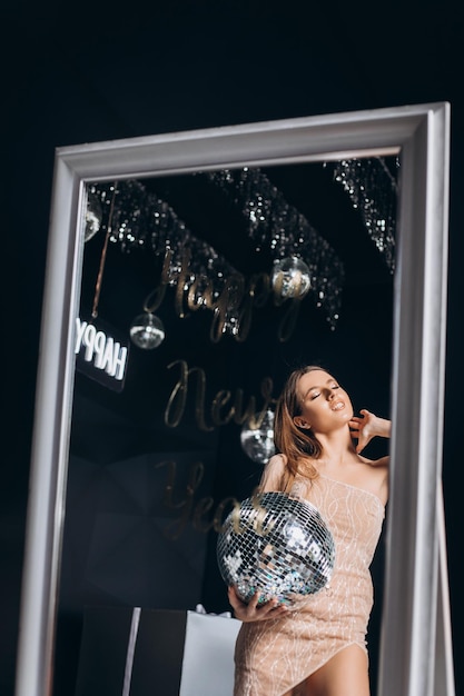 クリスマスライトの背景上の美しい女性パーティーのコンセプト魔法のドレスで素敵なセクシーな女の子