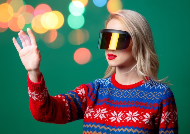 Beautiful woman in Christmas sweater and VR glasses  