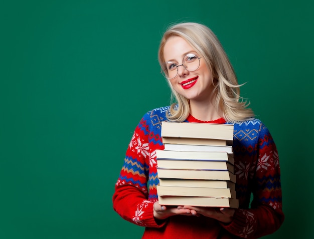 Beautiful woman in Christmas sweater with a books  