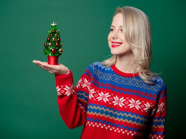 Beautiful woman in Christmas sweater with Christmas tree  