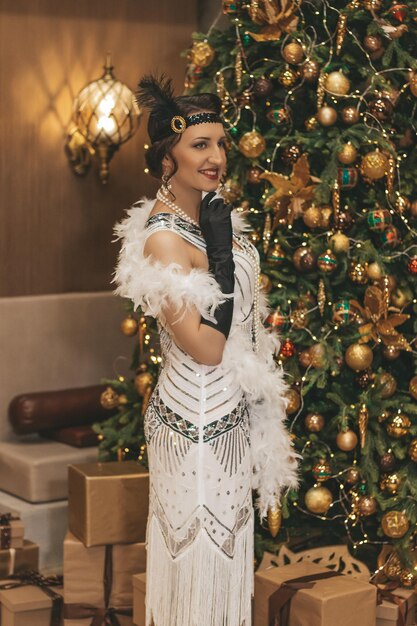 Beautiful woman close up on the decorated firtree background Gatsby style