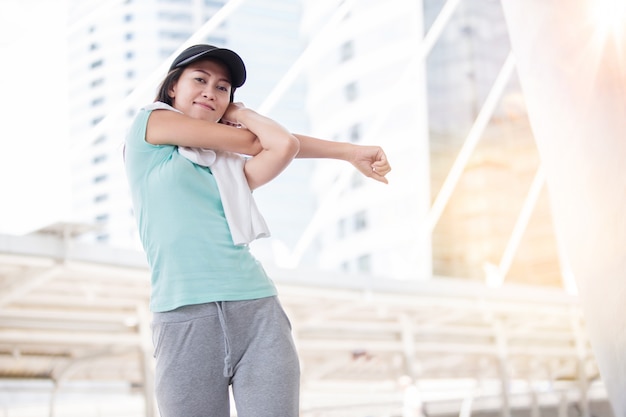 Photo beautiful woman  cool down after work out with white towel during sunset