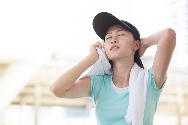 Photo beautiful woman  cool down after work out with white towel during sunset