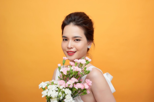 Beautiful woman Cute Asian girl feeling happy holding floral bouquet on yellow background - Beautiful woman lifestyle