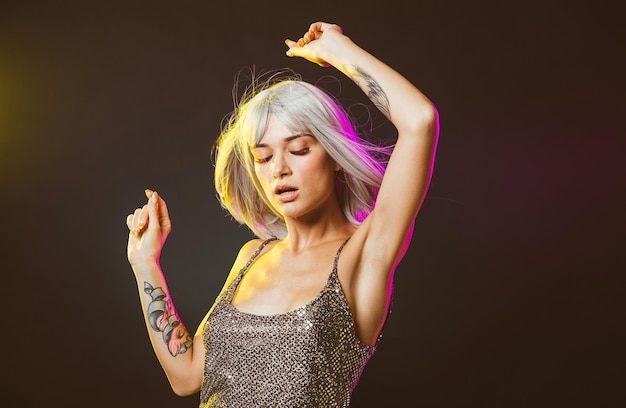 Beautiful woman dancing against black background