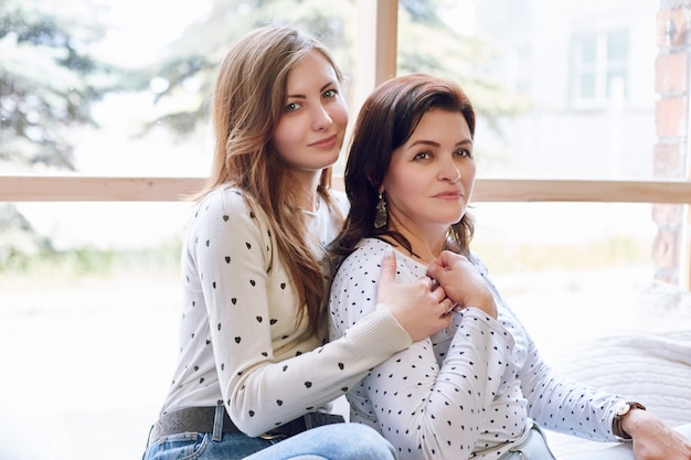 Beautiful woman and daughter, confident successful woman posing with daughter 