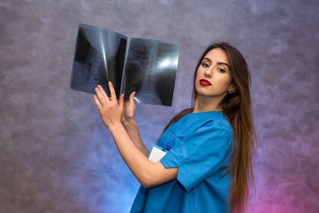 Beautiful woman doctor pointing at x-ray in hospital. Doctor making diagnosis