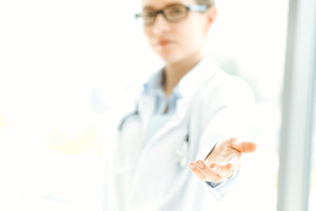 Beautiful woman doctor with stethoscope smiling charmingly and ready to help patients in the modern hospital Medicine concept