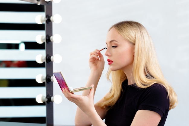 Beautiful woman doing evening makeup