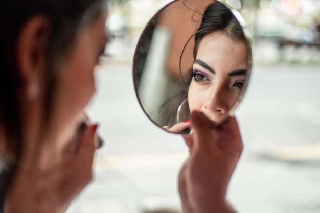 Foto una bellissima donna che si trucca guardandosi allo specchio