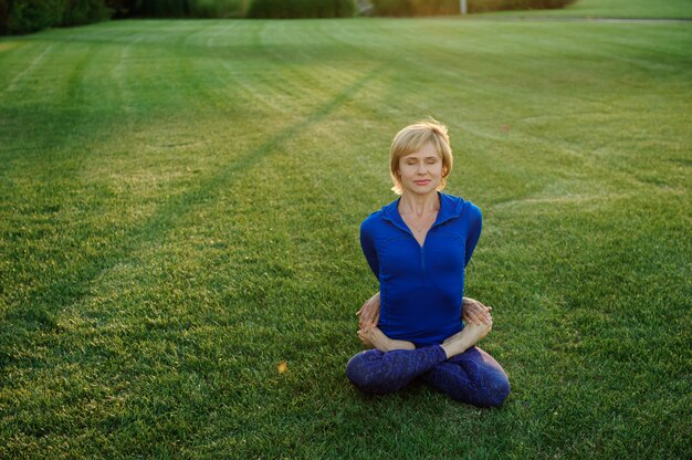 Beautiful woman doing yoga exercises in the park