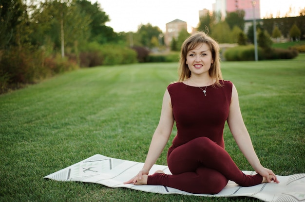 Beautiful woman doing yoga exercises in park