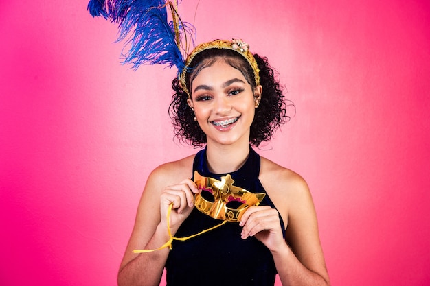 Foto bella donna vestita per la notte di carnevale. donna afro con trucco di carnevale