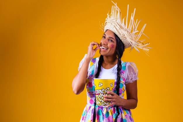 Beautiful woman dressed in June party outfit eating popcorn