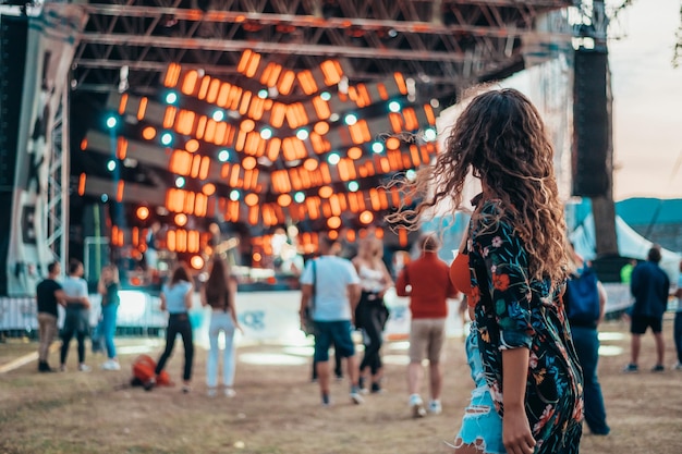 Photo beautiful woman drinking beer and having fun on a festival with her friends