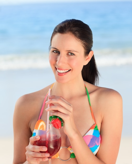 Beautiful woman drinking cocktail on the beach