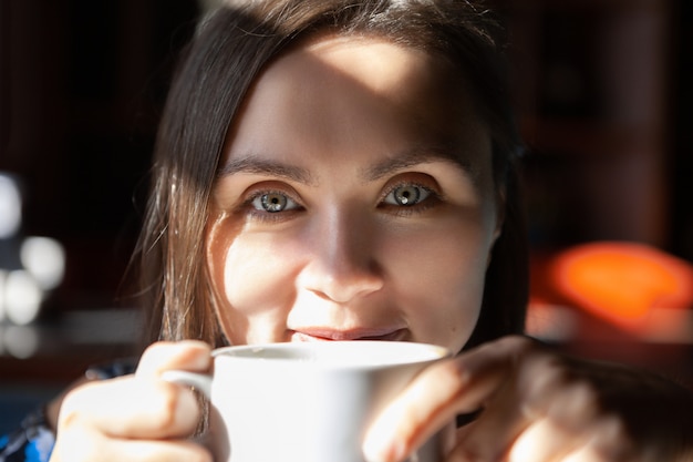 朝のカフェでコーヒーを飲みながら美しい女性。