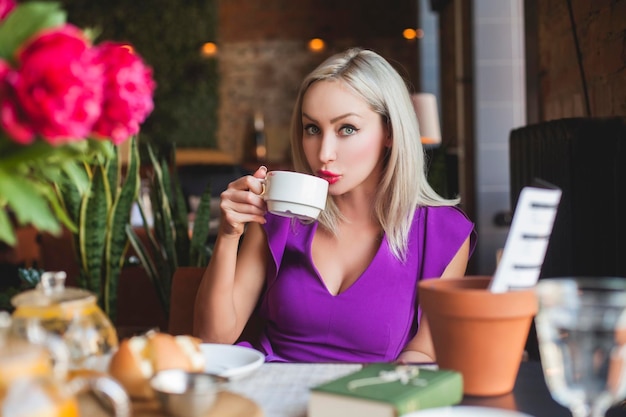 Beautiful Woman Drinking Coffee in Restaurant