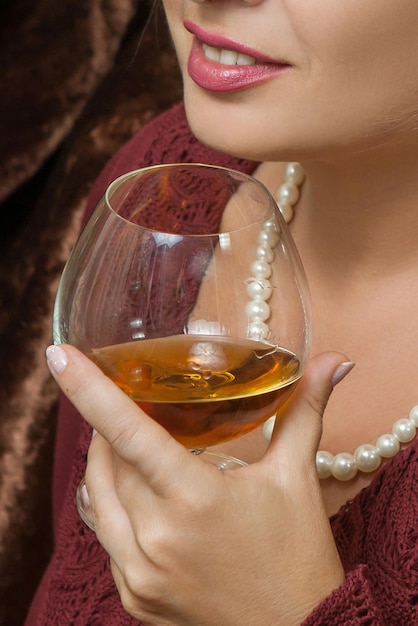 Beautiful woman drinking cognac