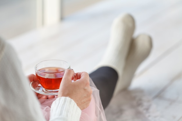 Bella donna che beve una tazza di tè in camera da letto al mattino