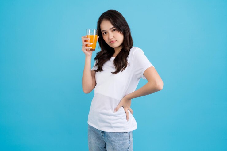 유리에서 오렌지를 마시는 아름 다운 여자