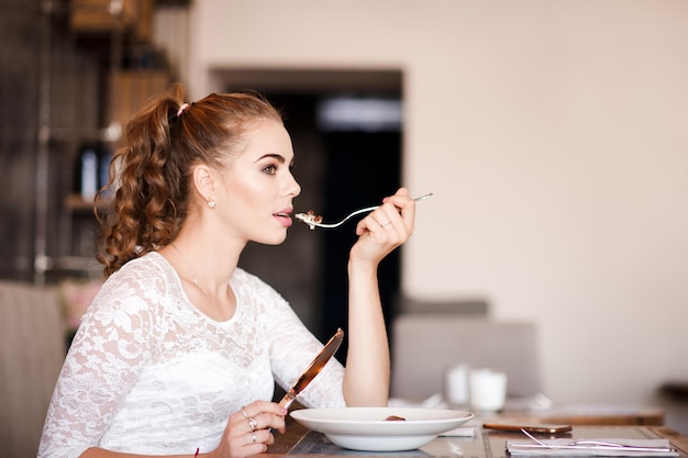 Beautiful woman eating in cafe