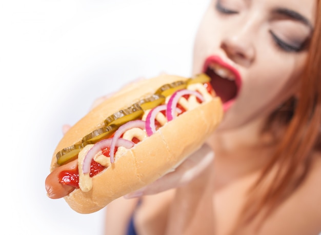 Beautiful woman eating a hot dog