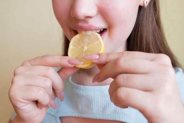 Beautiful woman eating lemon closeup