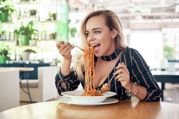 Photo beautiful woman eating spaghetti