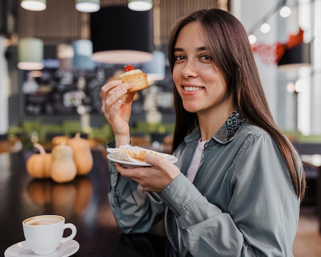 Bella donna che gode di un caffè e di una torta