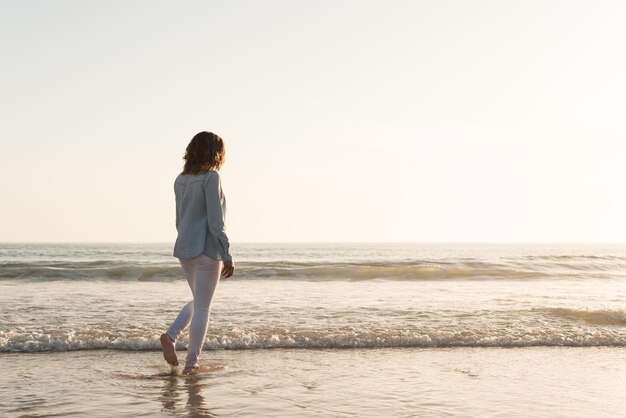 Beautiful woman enjoying sunset at the beach