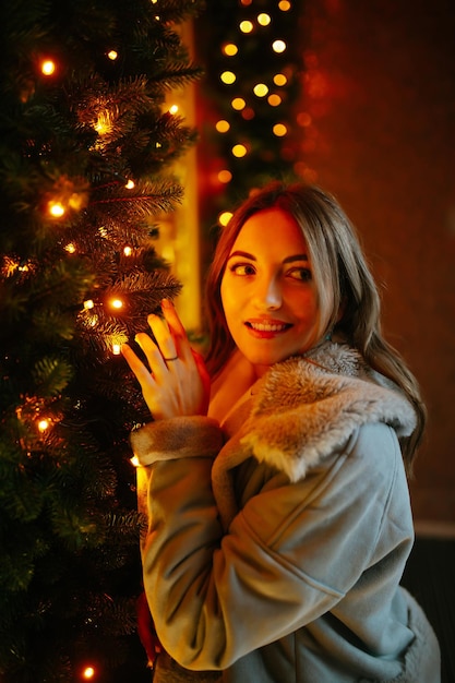 Beautiful woman enjoying winter holidays on Christmas market. Lights around.