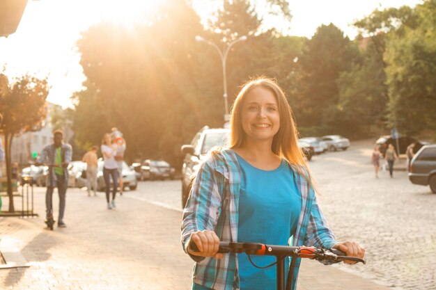 The beautiful woman enjoys riding an electric scooter