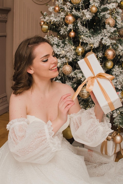 Beautiful woman in evening dress near the Christmas tree