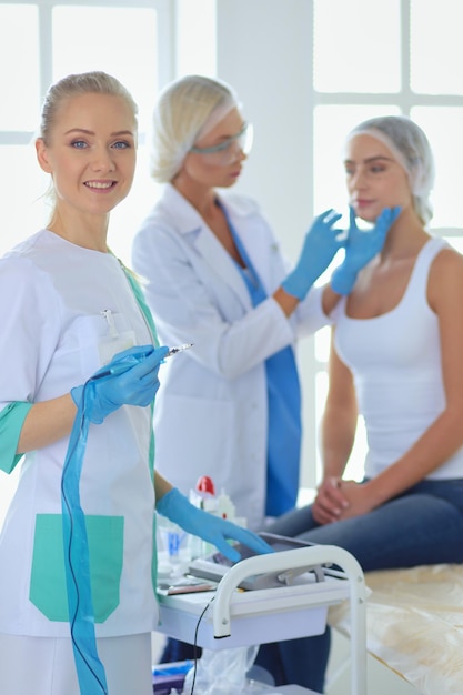 Beautiful woman face near doctor with syringe.